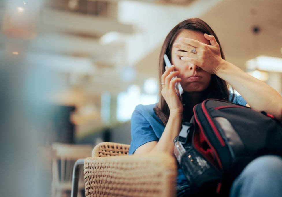 Stressed traveler speaking on her cellphone feeling overwhelmed